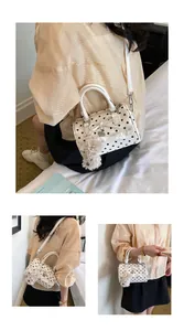 Stylish white polka dot Boston bag for women with bow and cute fluffy dog charm