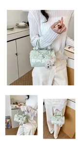 Exquisite mint green polka dot Boston bag with lace trim and a plush dog charm.