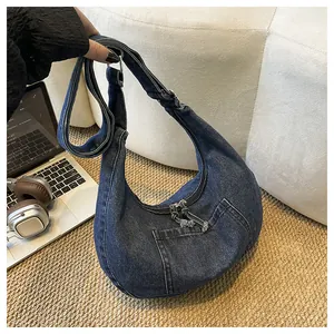 Spacious blue denim hobo bag for women featuring a functional front pocket and wide strap
