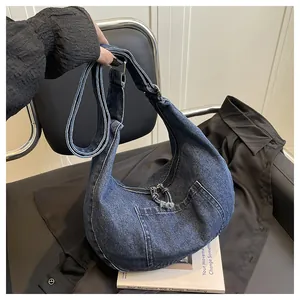 Detailed view of large blue denim hobo bag with zipper and exterior pocket for daily use