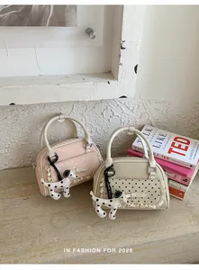 Detailansicht von zwei eleganten Handtaschen mit Dalmatiner-Anhängern und Spitzen.