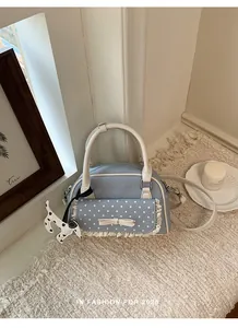 Elegante hellblaue gepunktete Handtasche mit Spitzenbesatz und süßem Hundekopf-Anhänger.