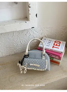 Blaue Denim-Handtasche mit Punkten, Spitze und Welpenanhänger im Lifestyle-Look.