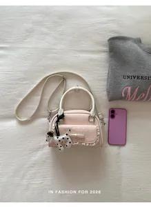 Flachbild eines rosa Handtasche mit weißen Griffen und einem Dalmatiner-Hund-Anhänger.