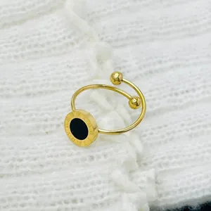 Detailed view of a gold titanium steel ring with black Roman numeral disc design.