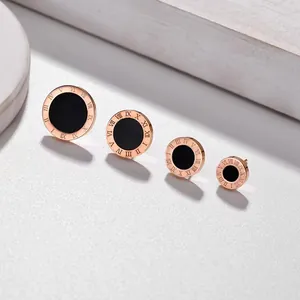 Detailed view of four sizes of rose gold Roman numeral stud earrings in titanium
