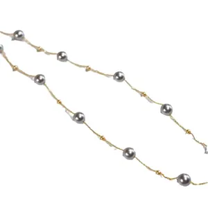 Close-up detail of a grey pearl starry necklace with 18k gold plated titanium chain.