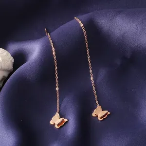 Détail de fils d'oreilles en titane or rose avec pendentifs papillon double dépolis