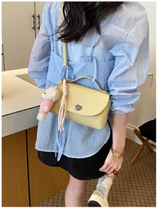 Vintage yellow textured crossbody bag with cute plush bear and tassel charm detail