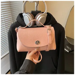 Stylish pink pebbled leather crossbody bag with adjustable strap and metal clasp.