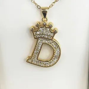 Detail shot of a gold-plated initial D necklace featuring a stone-set crown design