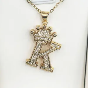 Close-up of gold-plated crown-topped letter R pendant necklace with sparkling cubic zirconia