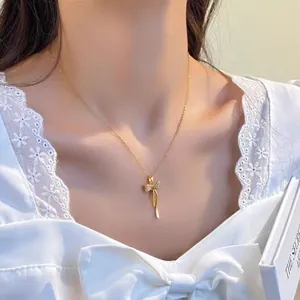 Vue détaillée d'un collier en acier titane doré avec pendentif nœud en cristal
