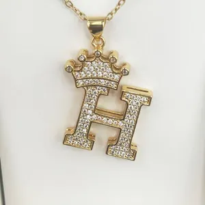 Close-up of a gold-plated letter H pendant necklace decorated with zircon crown detail