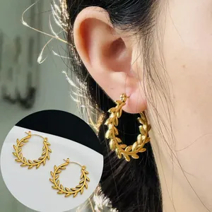 Detailed macro view of gold-plated wheat ear stainless steel hoop earrings worn on ear