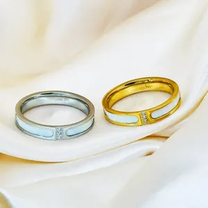 Close-up of minimalist stainless steel rings with white shell inlay and three stones