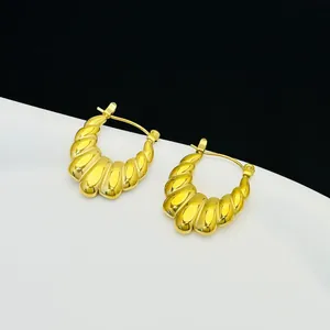Close-up detail of French style 18K gold plated stainless steel croissant hoop earrings.