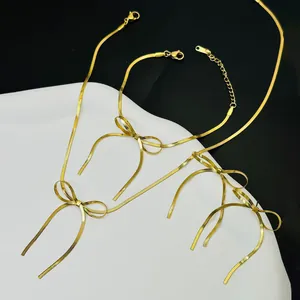 Gedetailleerd overzicht van elegante goudkleurige strikoorbellen en sieradenset.
