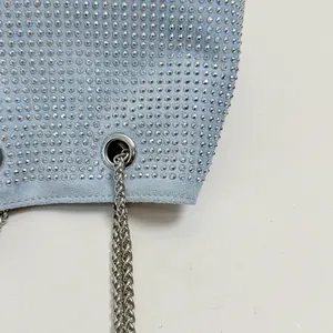Macro view of a light blue suede bucket bag featuring dense rhinestones and silver chain