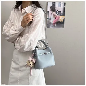 Elegante bolso cubo azul claro con patrón lichi y colgante oso