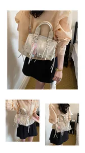 Detail view of a cream motorcycle bag with silver hardware and tassels worn by a model