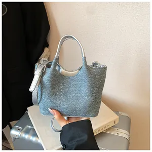 Blue denim quilted bucket bag with silver top handles and adjustable shoulder strap