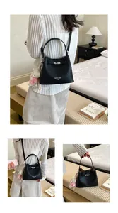 Women's black pebbled leather bucket bag with silver turn-lock in lifestyle setting.
