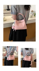Lifestyle view of a pink pebbled leather bucket bag with top handle and strap