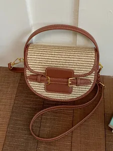 Elegant woven straw saddle bag with brown leather accents and top handle for vacation