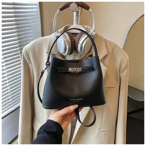 Close-up detail of black pebbled leather bucket bag with a silver turn-lock closure