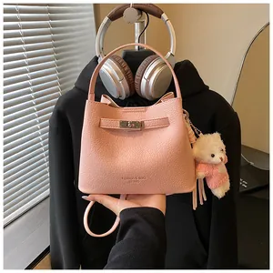 Chic pink leather bucket bag with top handle and cute bear charm detail