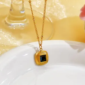 Close-up of a French retro gold necklace featuring a square green glass stone pendant