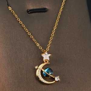 Detailed view of a gold fantasy planet necklace featuring moon and star zircon pendants