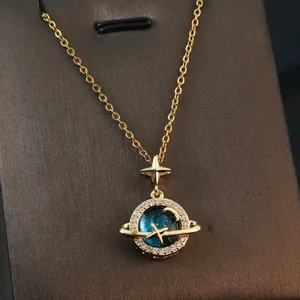 Detailed view of dreamy planet pendant necklace with shimmering zircons and stars.