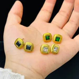 Detailed macro view of French retro threaded gold stud earrings with square glass stones