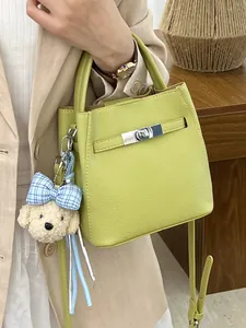 Bolso bombonera de piel verde lima con llavero de perro, elegante bolso bandolera de mujer.