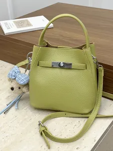 Elegante bolso de cubo en cuero verde para mujer con correa chic y colgante de oso