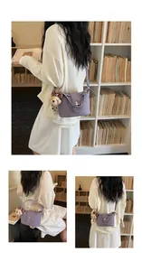 Detail view of purple textured leather bucket bag with a cute teddy bear charm