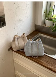 Sparkly rhinestone bucket bags in beige and blue with elegant chain straps for women.
