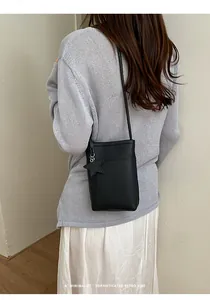Stilvolle minimalistische schwarze Beuteltasche mit Sternanhänger in der Rückansicht