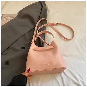 Chic pink textured leather bucket bag for women, perfect for elegant daily commuting.