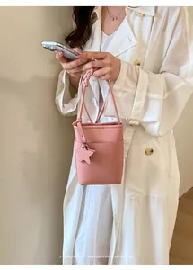 Detailansicht einer stilvollen rosa strukturierten Mini-Beuteltasche mit Sternenanhänger.