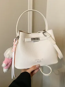 Elegant white textured leather bucket bag featuring a top handle and pink teddy bear charm