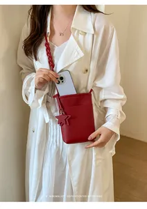 Rote minimalistische Umhängetasche für Handys mit Sternanhänger an einem Model