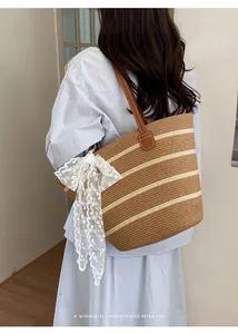 Vista posterior detallada de un bolso tote de paja a rayas con un lazo de encaje