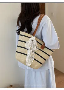 Elegante bolso tote de paja tejida a rayas con lazo de encaje en el hombro de modelo