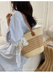 Vista detallada de un bolso de paja hecho a mano con cinta de encaje para estilo playero