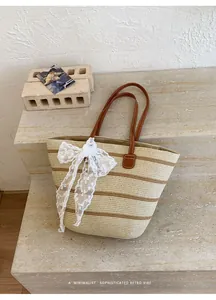 Detalle del tejido de paja y el elegante lazo de encaje de este bolso retro.