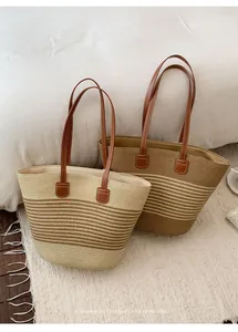 Vista detallada de la textura y el diseño de dos bolsos de playa de paja tejidos a mano.