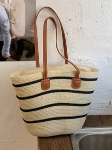 Bolso capazo de playa de paja tejida con rayas negras y asas de cuero marrón para mujer